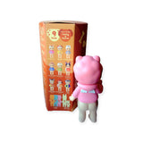 A pink bear figurine stands next to a toy box filled with collectible mystery figures, showcasing the charming Sonny Angel collectibles from the Dog Time Series and an array of other character designs.