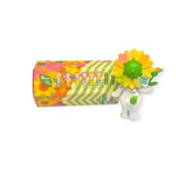 A Sonny Angel Flower Gift Series toy figure, featuring a vibrant flower head, is displayed beside a floral-patterned box, making it the ideal collectible gift. This delightful set from the Sonny Angel brand includes a collection of six similar mini figures.