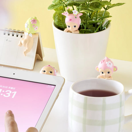 Cherry blossom Hippers mini figures peeking near a cup and potted plant