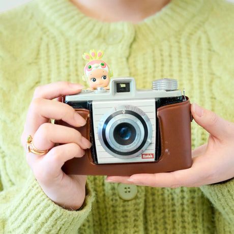 Cherry blossom Hippers mini figure on a brown camera held by hands
