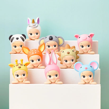 The Sonny Angel Hippers Blind Box - Animals by Sonny Angel includes ten toy figurines adorned with animal-themed hats, such as unicorns, pandas, and koalas. These figures are displayed on a tiered white platform and each comes with reusable adhesive for easy repositioning.