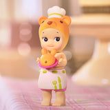 Featuring a delightful toy figure from the Sonny Angel Home Sweet Home Series by Sonny Angel, this adorable item is dressed as a chef, complete with a bear-themed hat and apron while holding a bear-shaped loaf of bread. This charming piece adds warmth and makes for a cozy companion in any collection.