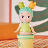 One of Robby's cheeky cameos features a doll from the Sonny Angel Home Sweet Home Series, dressed as a cactus with a green and yellow outfit, standing in a decorative pot against a colorful background.