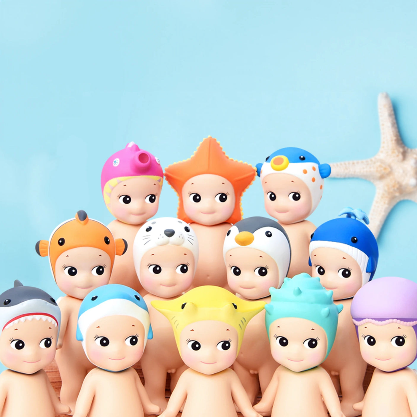 A cheerful assembly of small plastic figurines wearing vibrant animal-themed hats stands happily in front of a starfish. This captivating collection, from the Sonny Angel Marine Series by Sonny Angel, is truly a collector's dream.