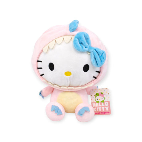 Discover the Hello Kitty: Kawaii Kingdom Plushies - 25cm, featuring a soft and huggable Hello Kitty in a pink dinosaur outfit with blue accents and a cute blue bow. She holds a "Hello Kitty x Dinosaurs" tag, ideal for collectors.