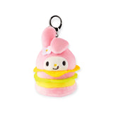 The Hello Kitty Snack Plush - Blind Bag by Hello Kitty features a pink character with bunny ears and a flower, nestled between yellow and pink cushions, similar to Sanrio keychains.