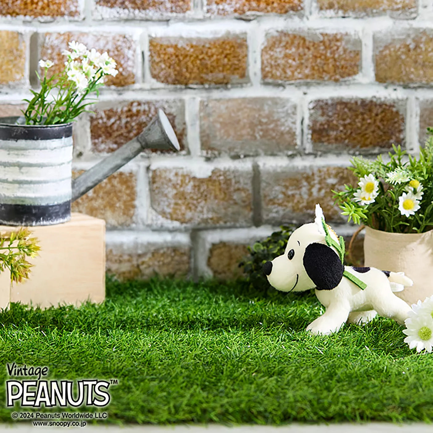 Snoopy plush keychain sitting with flower accessory and gold beaded chain