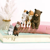 The Sleepy Animals Blind Box by Yell features five miniature figurines, including four cats and a bear, all sitting on the edge of two stacked books. These adorable desk companions are perfect for your collection. Try to collect all five!