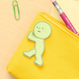 Yellow fabric embroidery patch with green character in a pushing pose