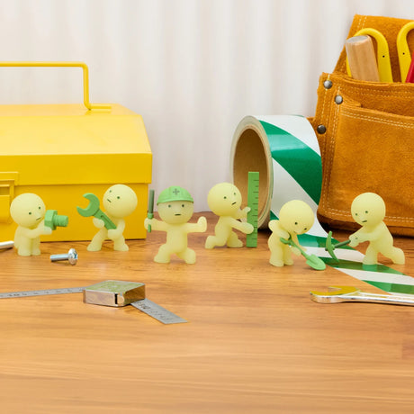 Multiple small yellow-green construction figures with tools and a rolled green-and-white tape