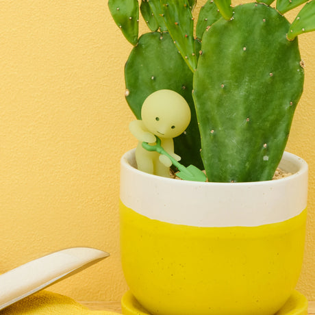 Smiski construction blind box figure beside cactus plant in yellow pot