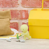 Smiski construction figure with small green-handled tool, light green mini near stones