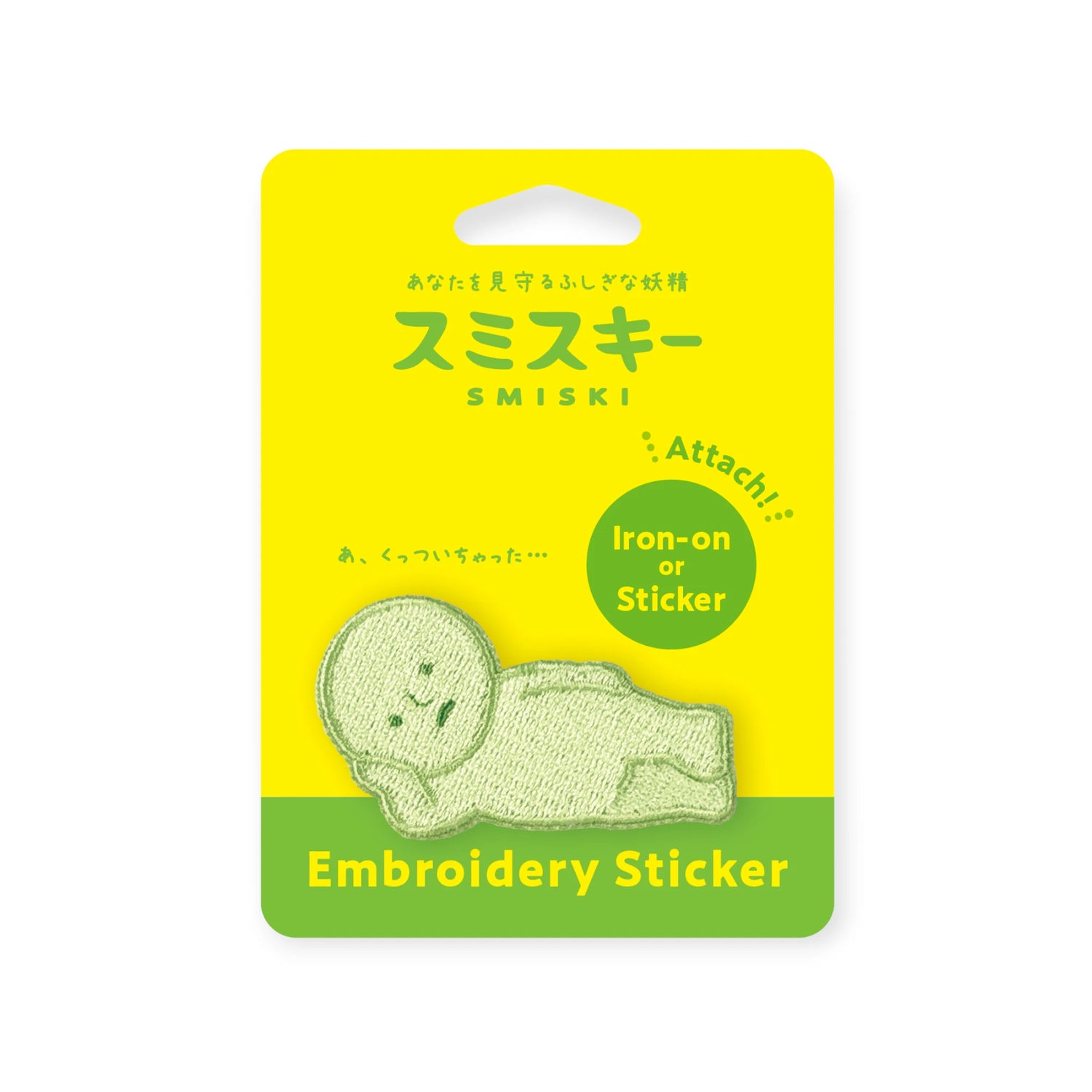 A green embroidered reclining figure accessory from Smiski is attached to yellow and green packaging labeled "Smiski Embroidery Sticker/Patch," ideal for fans of Smiski.