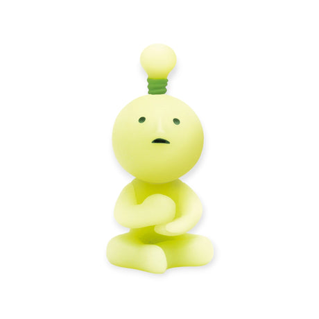 This delightful mystery from the Smiski At Work Series - Blind Box by Smiski is a small glow-in-the-dark figurine featuring a lightbulb-shaped head. Sitting cross-legged with its hands together, it stands out beautifully against a white background.