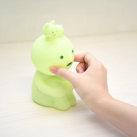 Pale green hugging knees touch light figure with hand pressing its side