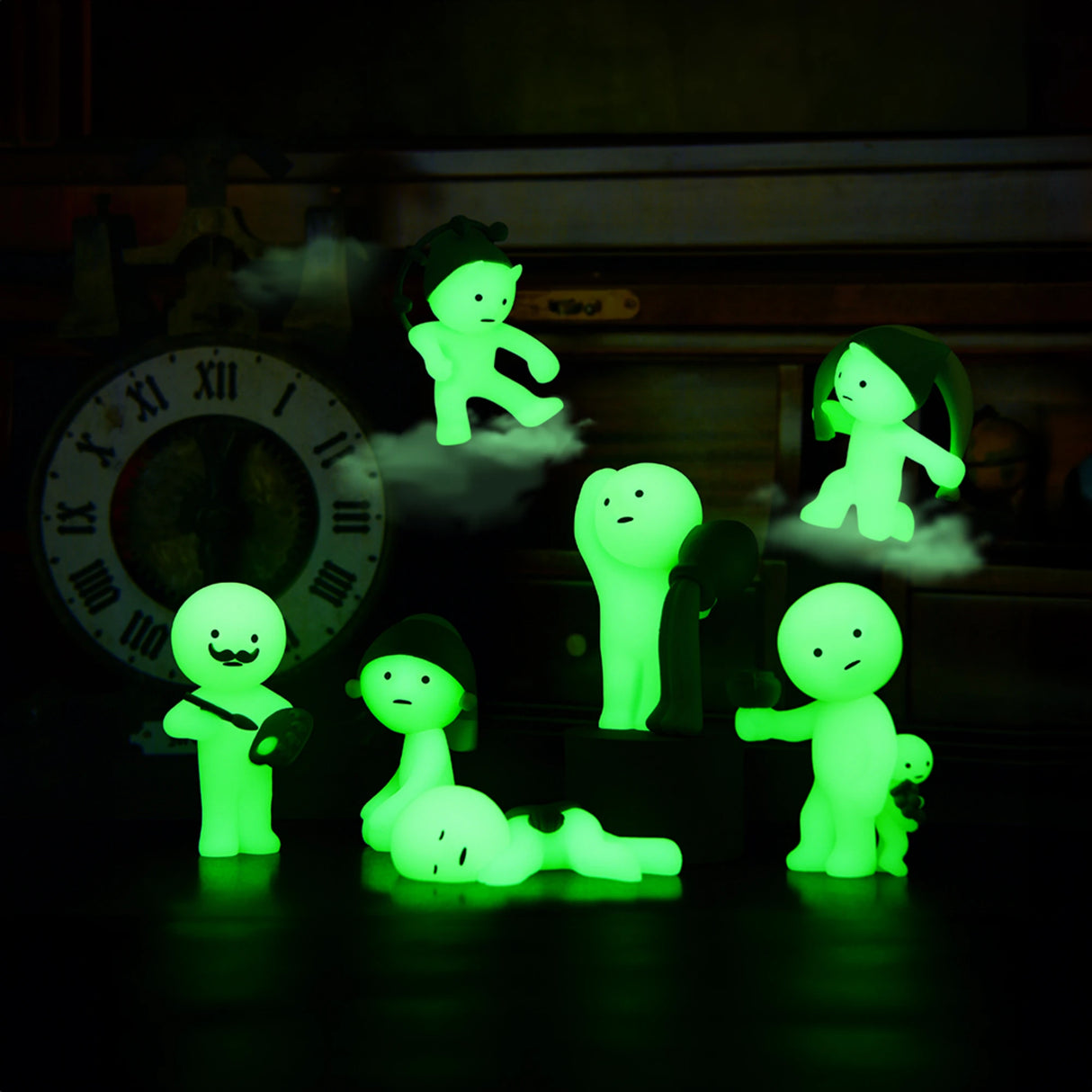 The Smiski Museum Series - Blind Box by Smiski features creative companions that glow in the dark while striking various poses on a table, accompanied by the subtle ticking of a clock in the background.