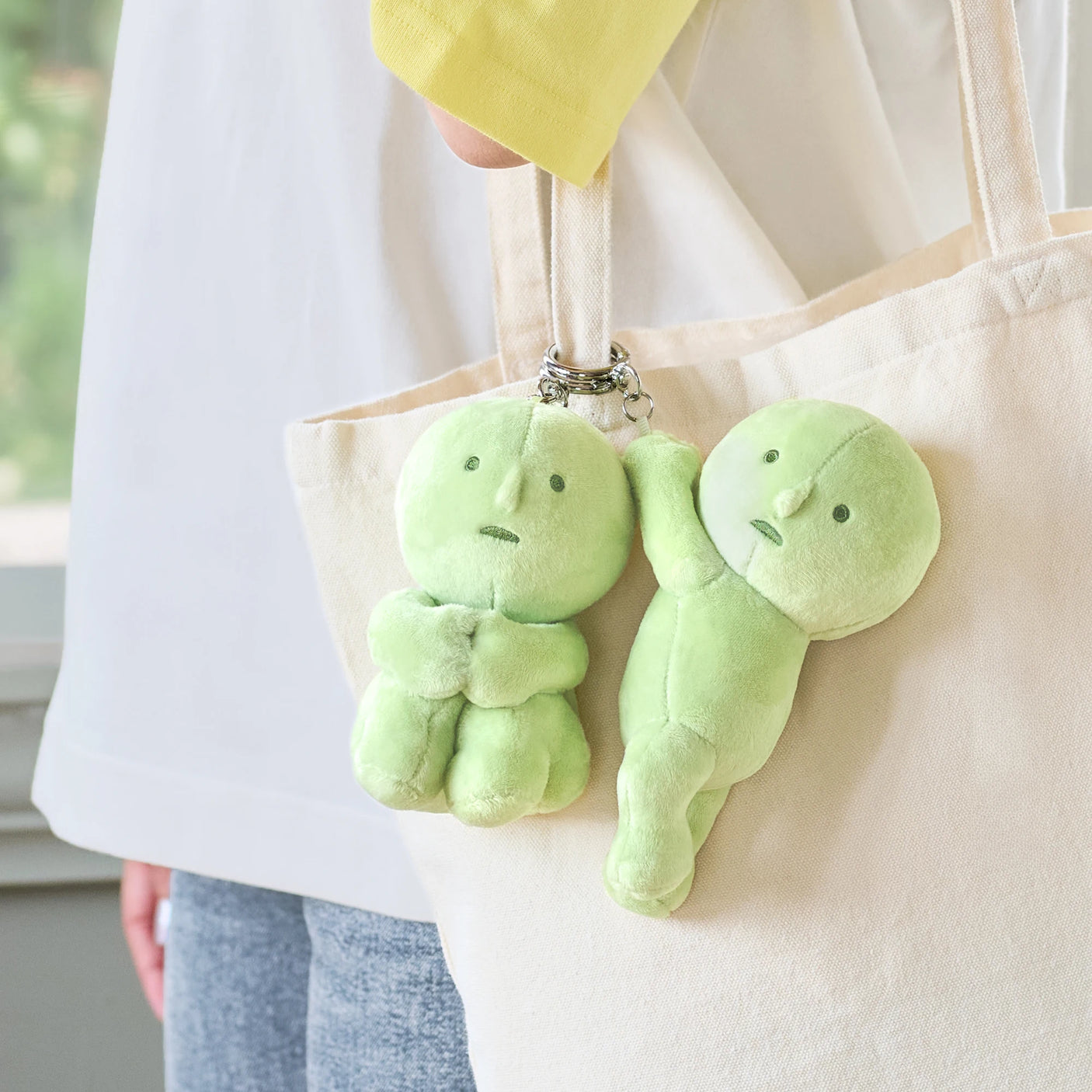 Pair of green plush keychains on tote strap with metal key rings