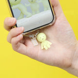 Smiski-style figure keychain charm dangling from a hand-held metal clasp