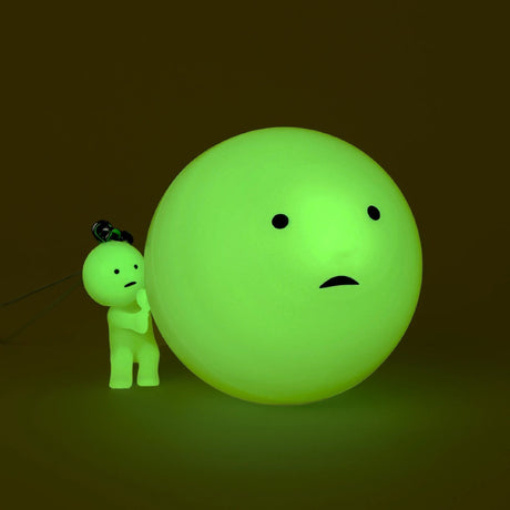 Smiski-style figure keychain beside a bright green ball charm
