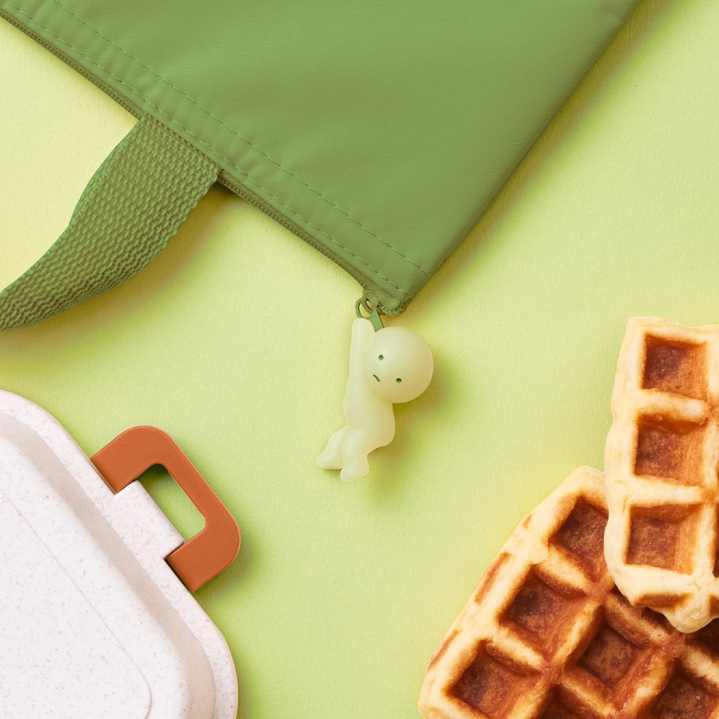 Hanging zipper bite figure on light green fabric zipper with pull tab