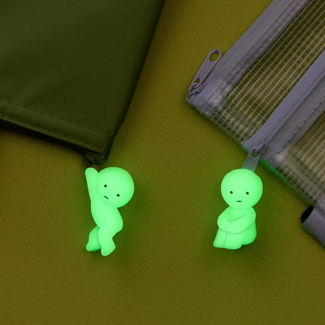 ZipperBite zipper pull accessory with glowing green Smiski figure on a zipper