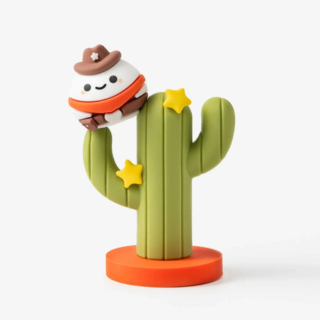 Small white character wearing a brown cowboy hat and orange bandana sitting on green cactus with yellow stars on orange base