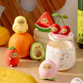 Assorted fruit blind box toy figures with a round container and small character pieces