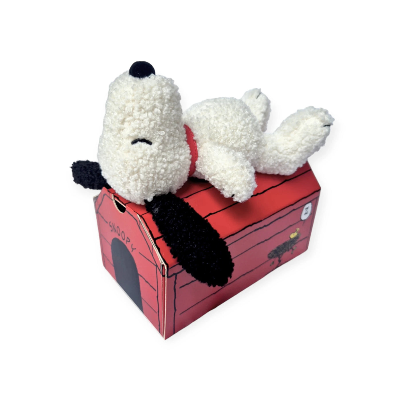 The perfect addition to your Doghouse Gift Set is a Snoopy Plush relaxing on a red, cartoon-style doghouse with a "Snoopy" sign. Introducing the Snoopy Plush Doghouse Gift Set - 17cm by Snoopy.