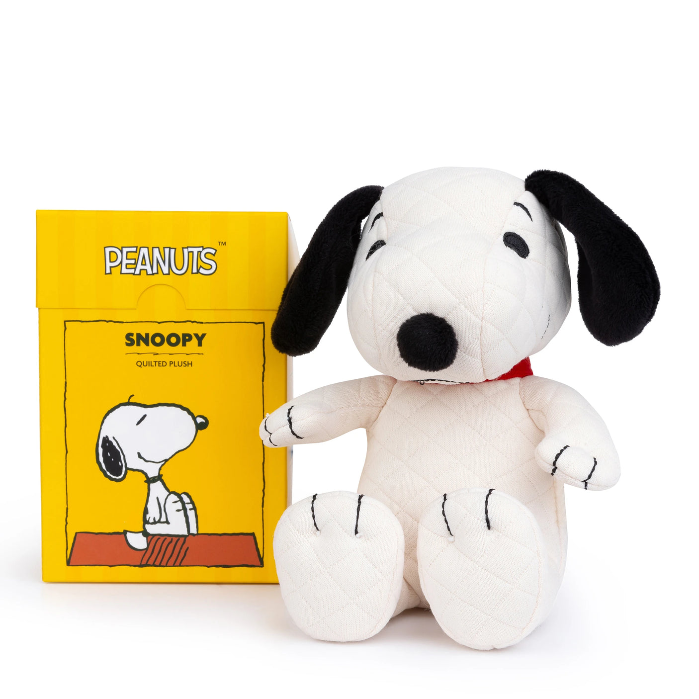 A Snoopy Quilted Plush in Gift Box – 17cm snuggles beside its yellow packaging adorned with a delightful Snoopy illustration, an ideal gift for any Peanuts enthusiast.