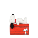 The Snoopy Plush Doghouse Gift Set - 17cm features a white dog plush with a black nose and ears, resting on a red, doghouse-shaped block adorned with the same cartoon dog's image, capturing the essence of Peanuts Magic.