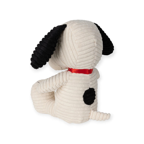 Introducing the Snoopy Plush Sitting 19cm in Corduroy Cream from the Snoopy brand, this charming plush showcases a cream-colored body with black ears and a unique black spot on its back. Perfectly designed for any Peanuts enthusiast, it sits facing away with a vibrant red collar.