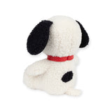 The Snoopy Plush Sitting 20cm - Terry Cream from the Snoopy brand features a cute terry cloth design with black ears and a distinctive black spot on its back. This plush toy sits upright, facing away, and wears a red collar. Filled with cozy, recycled polyester, it remains both huggable and eco-friendly.