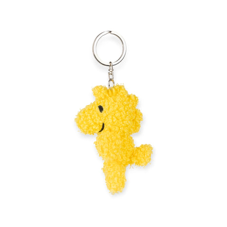 Introducing the Snoopy Woodstock Keychain 7cm, a charming piece from the Snoopy collection. This keychain features Woodstock, a small bird crafted from soft Terry plush with black eyes and a cheerful smile. It is attached to a sleek silver keyring for convenient carrying.