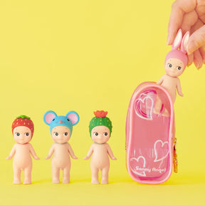 Four small Sonny Angel dolls with unique headgear (strawberry, mouse, cactus, bunny) are displayed next to the Sonny Angel My Bestie Case - Purple by Sonny Angel against a yellow background—ideal for storing or showing off your mini figures.