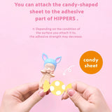 Candy-shaped adhesive sheet and small character figure, held by hands