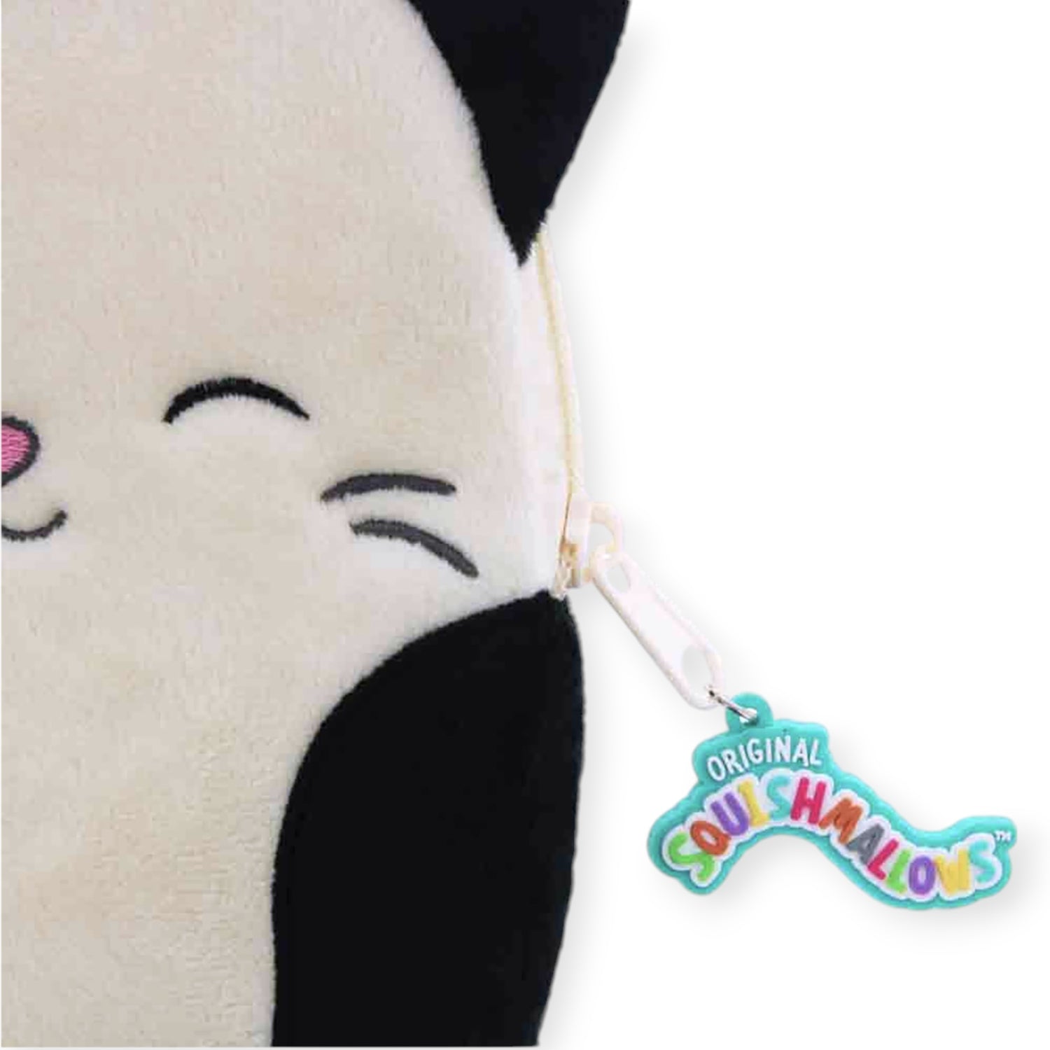 Close-up of the Squishmallows Calico Cat Plush Case, featuring black ears and an "Original Squishmallows" tag attached by a keychain. This charming plush case is ideal for storing your essentials or adding a touch of cheer to any space.