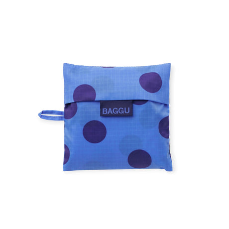 Folded blue polka dot Baggu bag with strap and logo patch