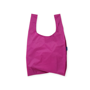Bright magenta reusable shopping bag with wide handles and compact, foldable design against a white background