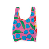 The Baggu Standard Reusable Bag from Baggu is designed with eco-chic style, showcasing a pink background adorned with blue apples and green bananas for a sustainable look.