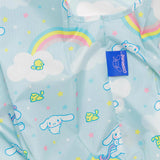 A Baggu Standard Bag in light blue displays clouds, rainbows, stars, and cartoon animals such as a blue-eared character and small yellow creatures, featuring a "Cinnamoroll" label by Sanrio.