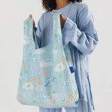 A person holding a vibrant Baggu Standard Bag - Cinnamoroll, featuring playful rainbow and cloud patterns, reminiscent of a Sanrio creation.