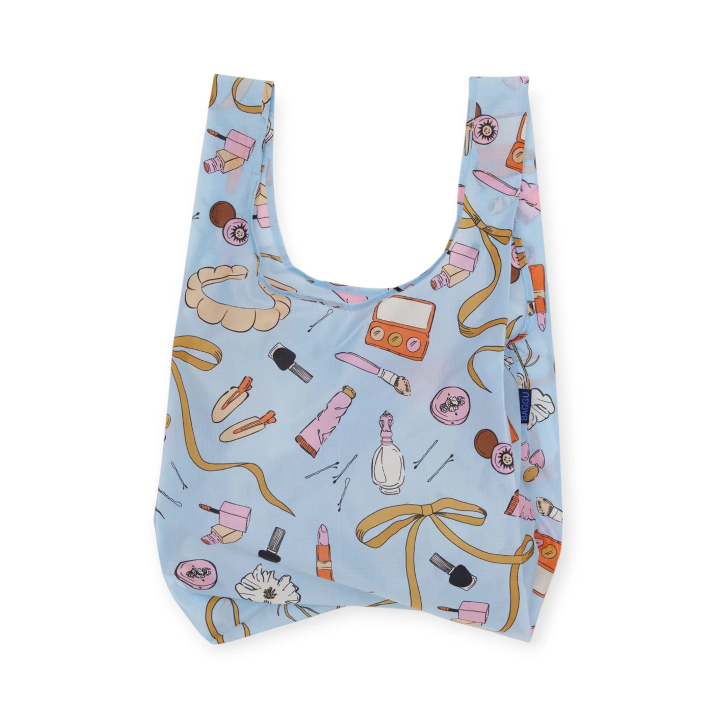 The Standard Baggu Bag, "Get Ready With Me," by Baggu features a light blue background and playful colorful makeup prints. Crafted from recycled ripstop nylon, it showcases lipsticks, brushes, and eyeshadow palettes.