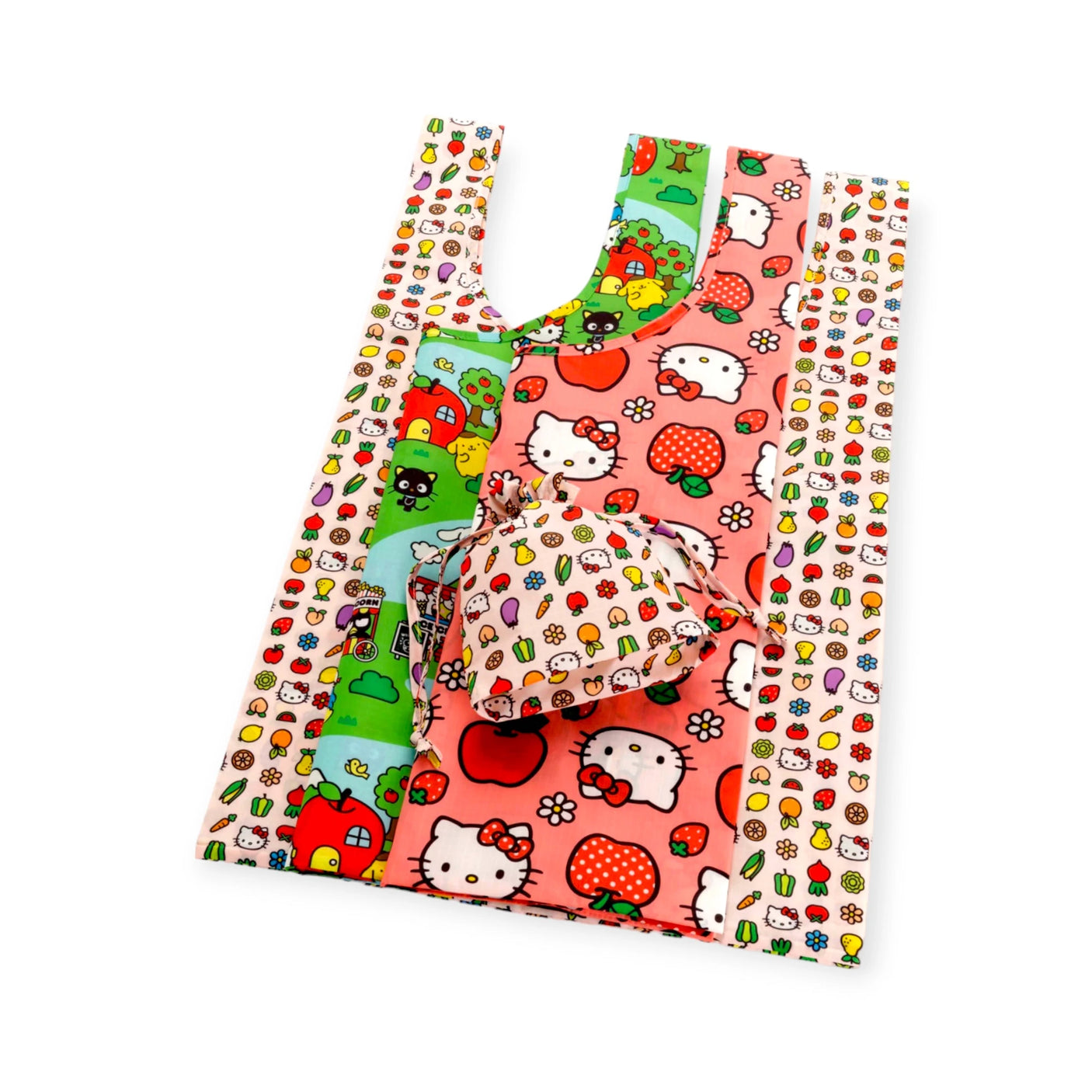 A set of three standard bags from the Hello Kitty x Baggu collaboration showcases a vibrant mix of cartoon characters, strawberries, and apples on a pink and multicolored recycled polyester canvas.