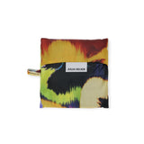 The Standard Baggu x Julia Heuer - Pansy pouch features a vibrant abstract design in warm and cool colors with recycled nylon, a black band, and a central "JULIA HEUER" label, capturing the essence of this creative collaboration.