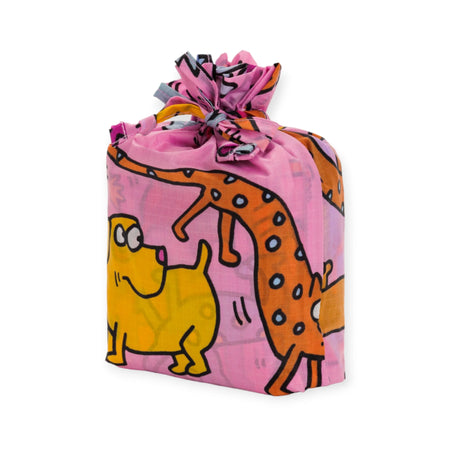 Keith Haring x Baggu Set of 3 Standard Bags by Baggu, featuring a playful design with cartoon animals on recycled nylon fabric, including a yellow dog and an orange spotted creature set against a pink background, tied securely with a knot on top.