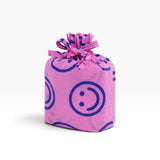 Purple cloth drawstring bag with smiley face print and gathered bow at top.