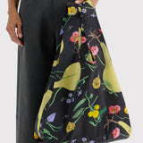 Botanical print tote bag in use, held by top handles