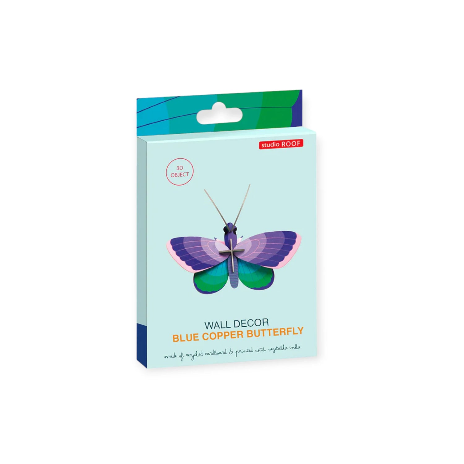 A Studio Roof box labeled "Wall Art Puzzle - Blue Copper Butterfly" features a 3D butterfly illustration. The light blue packaging with colorful accents and a product window highlights this unique wall decor piece.