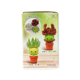 A display box contains two toy plant figures in small pots with cartoon faces. The top one looks like grapes, and the bottom is a mystery succulent with aloe-like leaves. It's labeled in Japanese, recommended for ages 8+, and ideal for Kitan Club's Succulent Friends Blind Box fans!.