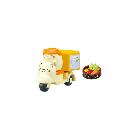 A Sumikko Gurashi cat from the Re-Ment Sumikko Gurashi Food Delivery Blind Box playfully zips around town on a yellow delivery scooter, as if on a food delivery mission, with a small dish of food accompanying it.